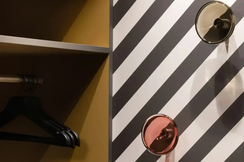 Wandhaken mit Kugelknöpfen vor diagonal gestreifter Wand im Haus 3 des Hauses der Standesbeamten