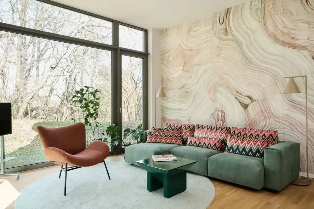Wohnzimmer mit grünem Sofa und Marmor-Wandtapete in der Ferienwohnung in Fulda