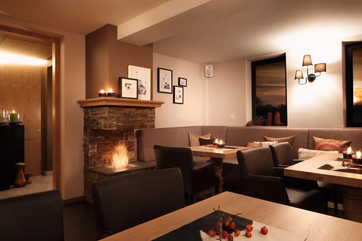Gastraum des Hotels Taufstein mit Eichentischen, Polsterbänken und Kamin
