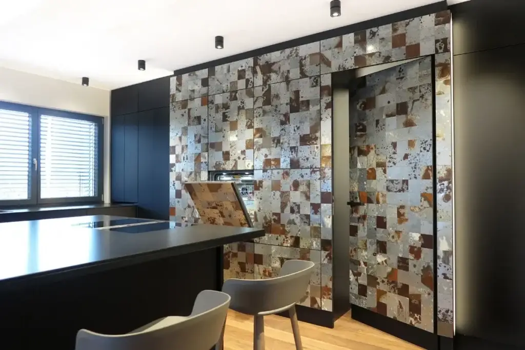 Hochschrankwand mit Fliesenmosaik und offener Klappe neben Kochinsel im Haus S in Sommerach