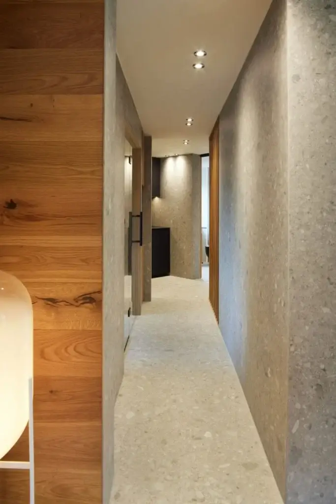 Schmaler Gang mit Terrazzowänden und Eichenholz in der Private Wellness Suite