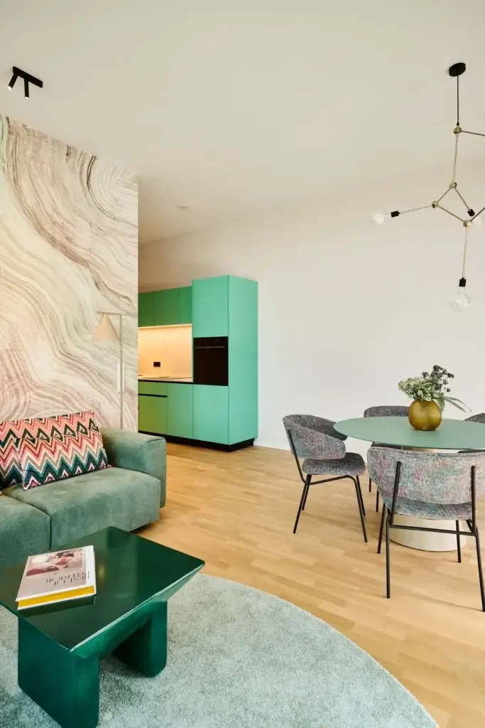 Wohn- und Essbereich mit grünem Couchtisch und runder Essgruppe in der Ferienwohnung
