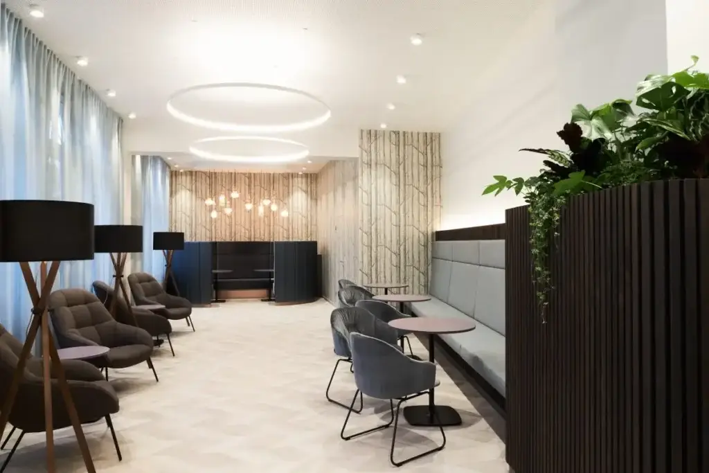 Lobby mit Loungesesseln, Stehtischen und Pflanzen im Haus der Standesbeamten