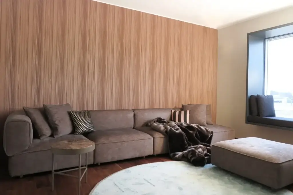 Wohnbereich mit taupefarbenem Ecksofa, Hocker und Streifentapete im Haus S in Sommerach