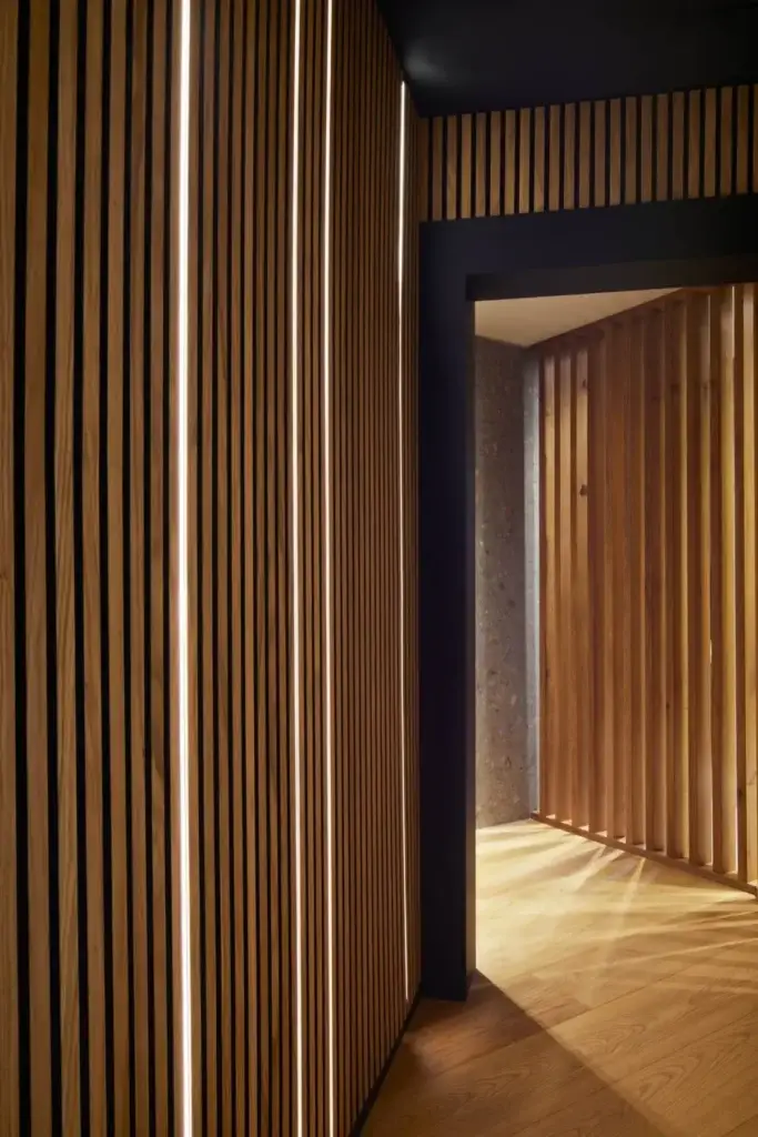 Durchgang mit Holzlamellen aus Eiche und Lichtstreifen in der Private Wellness Suite