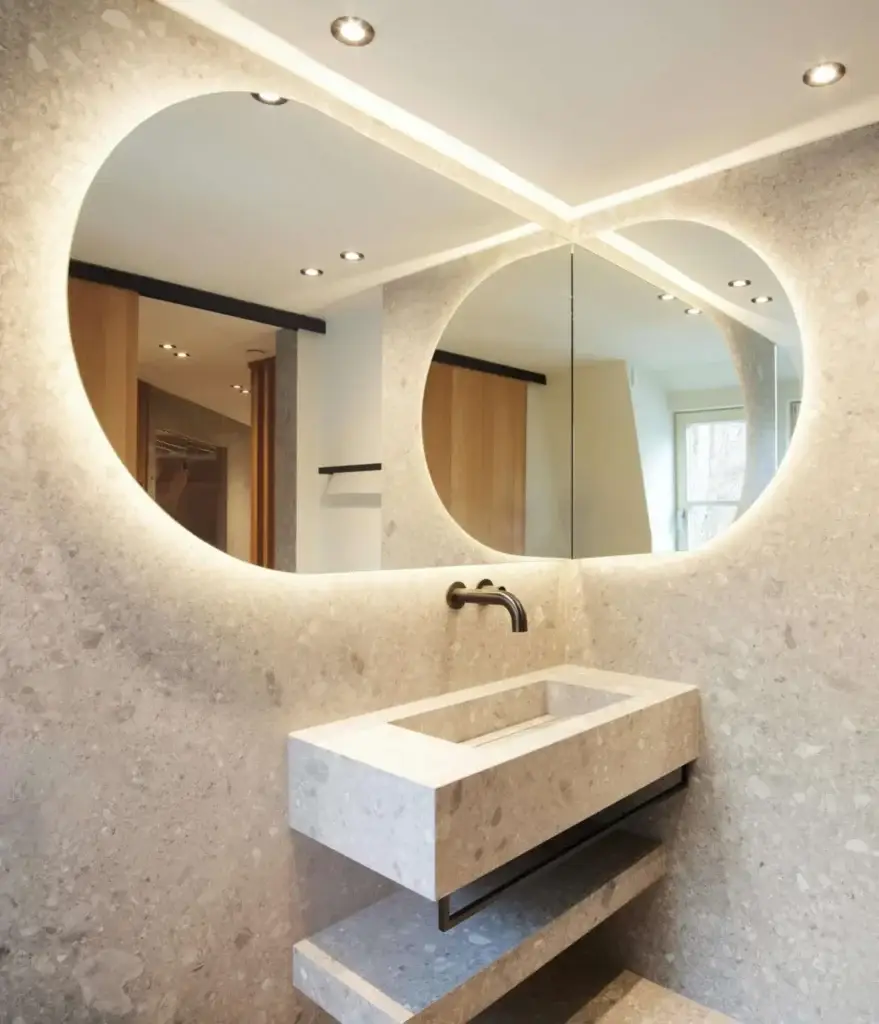 Waschtisch aus Terrazzo mit zwei beleuchteten Rundspiegeln in der Private Wellness Suite