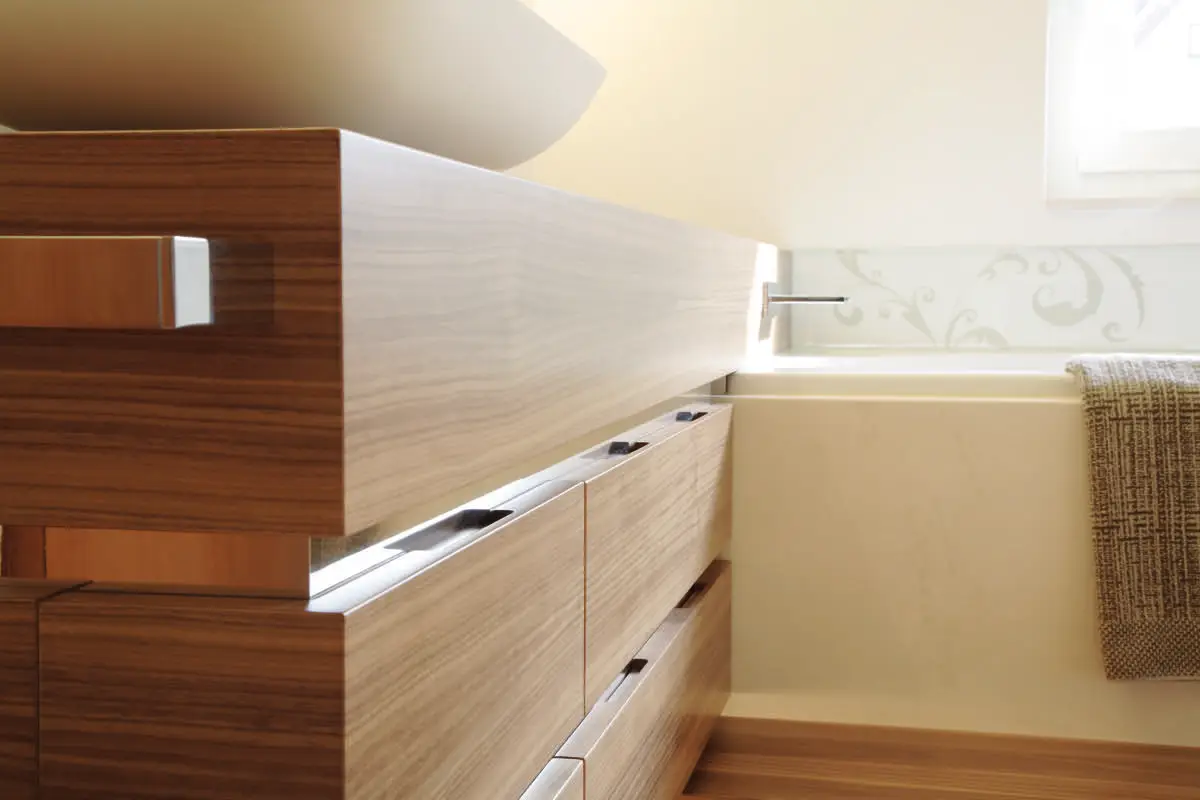 Unterschrank und Hochschrank aus Nussbaumfurnier mit Chromeinlagen im Bad G in Flieden