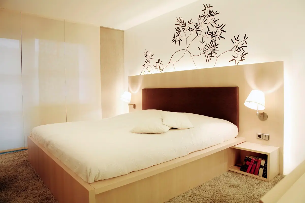 Schlafzimmer mit Bett, gepolstertem Kopfteil und Maßmöbeln in der Wohnung K