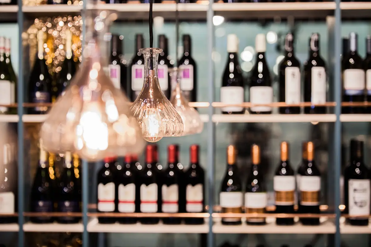 Petrolfarbene Weinregale mit Pendelleuchten bei Bruno's Finest Food