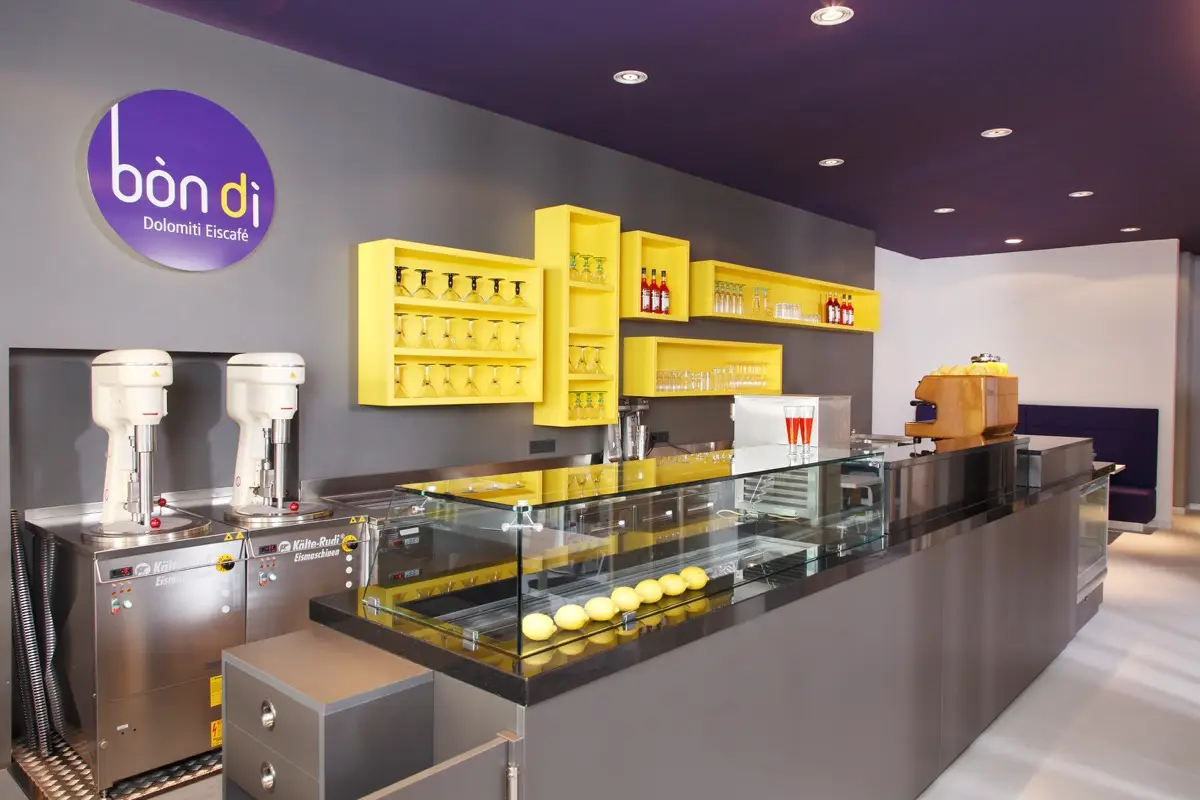 Theke des Eiscafés Bondi mit Vitrine, gelben Regalen und violetter Decke