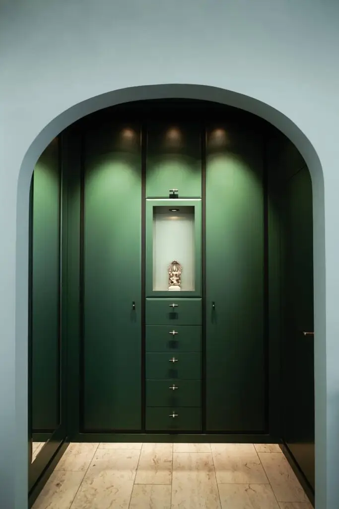 Grüner Einbauschrank mit beleuchteter Nische hinter einem Rundbogen in der Villa A